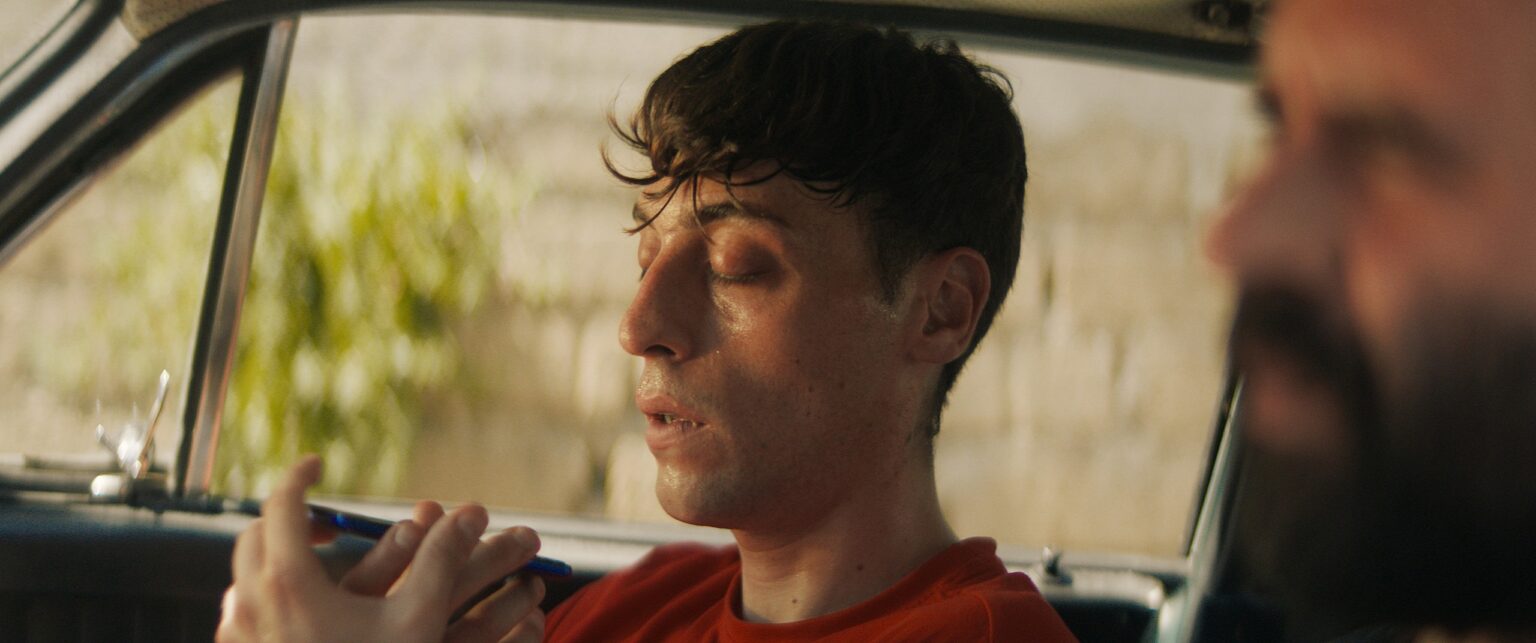 La Truffa, directed by Matteo Stipa and Michele Marchionne: Tommy talks, sitting in the car next to Frappa
